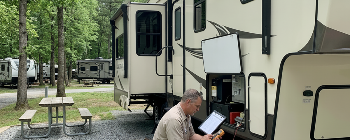Mobile RV technician inspecting a fifth wheel before the start of another travel season