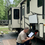Mobile RV technician inspecting a fifth wheel before the start of another travel season